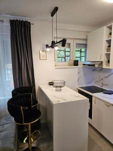 een keuken met een aanrecht en 2 barkrukken bij Apartment Mia in Mostar