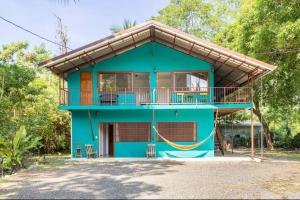 a blue house with a balcony at Casa Patricia in Uvita