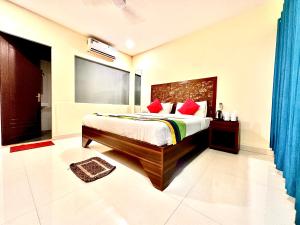 a bedroom with a bed with red pillows at Moon Bliss in Mandrem
