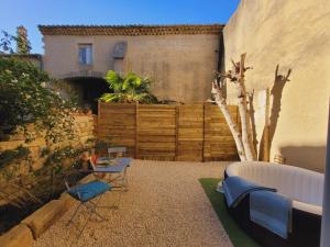 a backyard with a fence and a table and chairs at La Promenade Suite & Spa in Congéniès