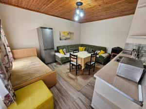 Apartment Koka في بيرات: مطبخ وغرفة معيشة مع طاولة وأريكة