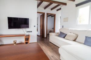 - un salon avec un canapé blanc et une télévision dans l'établissement House in Tarifa beach in Valdevaqueros, à Tarifa