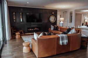 a living room with leather furniture and a fireplace at Eichardt's Private Hotel in Queenstown