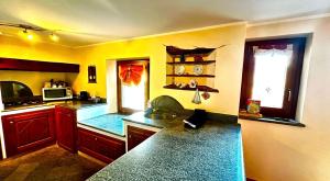 eine Küche mit gelben Wänden und einer blauen Arbeitsplatte in der Unterkunft Maison L’Abri in Introd