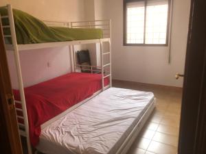 a bedroom with two bunk beds and a window at Dúplex con vistas panorámicas in Calabardina