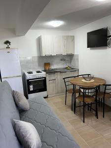 a living room with a couch and a table in a kitchen at Sunset apartment in Tivat