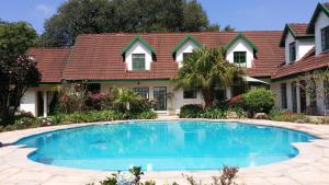 a house with a swimming pool in front of a house at Diggersrest Lodge in Haenertsburg