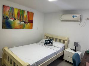 um quarto com uma cama e um quadro na parede em Cozy Apt in Coveñas CCampestre em Coveñas
