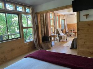 1 dormitorio con cama y ventana grande en Haiku Cabañas Panorámicas, en San José de Maipo