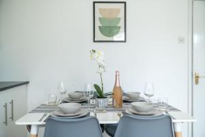 a dining room table with blue chairs and a bottle of wine at Prime Living in Guildford