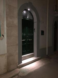 eine schwarze Tür in einem Gebäude mit Licht in der Unterkunft Dimora Gallo in Fasano