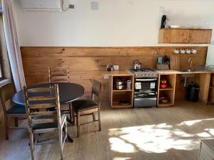 uma cozinha com uma mesa, cadeiras e um fogão em Haiku Cabañas Panorámicas em San José de Maipo