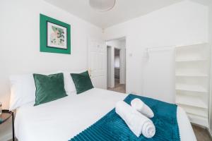 a bedroom with a large white bed with green pillows at Prime Living in Guildford