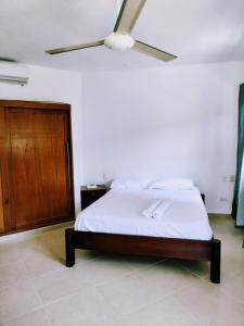 a bedroom with a bed with a ceiling fan at Okaina Studio Rooftop in Cabarete