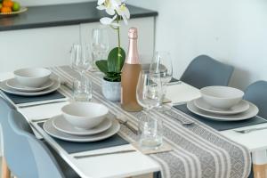 a dining table with white dishes and a bottle of wine at Prime Living in Guildford