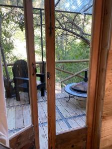 eine offene Tür zu einer Veranda mit einem Tisch und einem Stuhl in der Unterkunft Haiku Cabañas Panorámicas in San José de Maipo