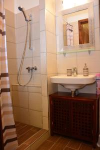 y baño con lavabo y ducha. en Bodza Apartmanok, en Eger