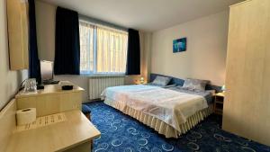 a hotel room with a bed and a television at Kaloyanova House Bansko in Bansko
