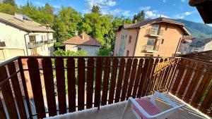 een houten balkon met een stoel en een gebouw bij Kaloyanova House Bansko in Bansko