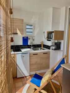 uma cozinha com uma cadeira, um lavatório e um fogão em Lever du soleil em La Trinité