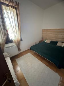 a bedroom with a green bed and a window at Casa Rosa in Elice