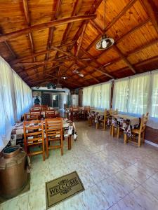 un restaurante con mesas y sillas de madera y techo de madera en Los Nonos en Villa Cura Brochero