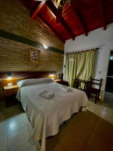 1 dormitorio con 1 cama grande en una pared de ladrillo en Los Nonos en Villa Cura Brochero