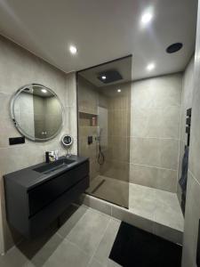 uma casa de banho com um lavatório e um chuveiro com um espelho. em The Loft, Marseille 8 ème em Marselha