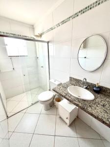 a bathroom with a toilet sink and a shower at Casa Ampla - Ótima Localização in Piracicaba