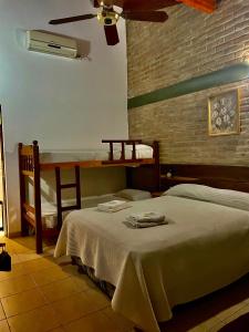 1 dormitorio con 2 camas y 1 litera con ventilador en Los Nonos en Villa Cura Brochero