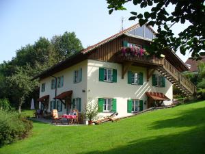 Une grande maison blanche avec volets verts dans l'établissement Bruckhuberhof, à Hirschbach