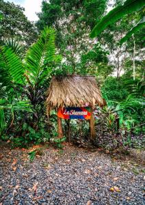 una pequeña cabaña con un cartel en un bosque en La Shamana - Ecological Concept in Jungle en Cahuita