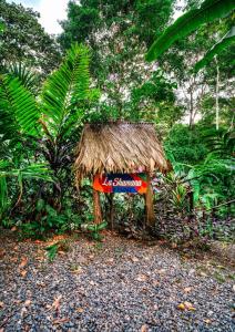 a small hut with a sign in a forest at La Shamana - Ecological Concept in Jungle in Cahuita