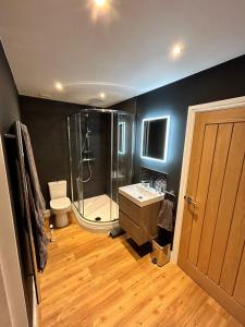 a bathroom with a shower and a toilet and a sink at Stansted Airport Stay, Parking and Luxury Suite in Birchanger