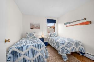 a bedroom with two beds and a baseball bat on the wall at 21 Dexter Avenue Sandwich - Creekhaven Cottage in Sandwich