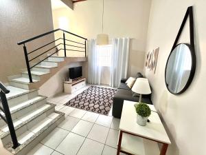 a living room with a staircase and a couch at Casa Ampla - Ótima Localização in Piracicaba