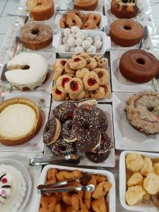 una mesa llena de diferentes tipos de donuts y repostería en Hotel Cambirela, en Palhoça
