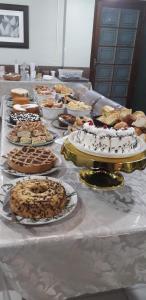 einen Tisch mit vielen verschiedenen Arten von Kuchen und Torten in der Unterkunft Hotel Cambirela in Palhoça