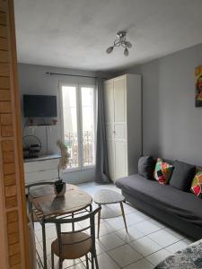- un salon avec un canapé et une table dans l'établissement Studio charmant centre d Aubervilliers, à Aubervilliers