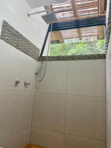 a shower in a bathroom with a window at Ecohotel Alma in Calarcá