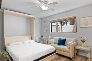 una camera con letto, divano e ventilatore a soffitto di Beach Road Condo, Patio, Siesta Key Village and Beach Walkable a Siesta Key