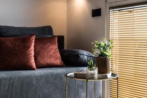 ein Wohnzimmer mit Sofa und Tisch in der Unterkunft Tucan - 77 Apartments Wigury - Dostęp na KOD - Parking - Smaczna Kawa - Centrum - Blisko Piotrkowska - Galeria - Widok na miasto - Klimatyzacja - 7 piętro - FV in Łódź