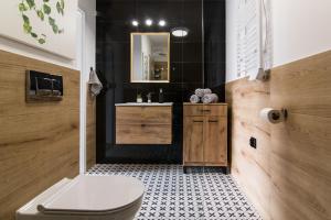 ein Badezimmer mit Toilette, Waschbecken und Spiegel in der Unterkunft Tucan - 77 Apartments Wigury - Dostęp na KOD - Parking - Smaczna Kawa - Centrum - Blisko Piotrkowska - Galeria - Widok na miasto - Klimatyzacja - 7 piętro - FV in Łódź