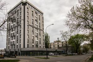 ein hohes weißes Gebäude auf einer Stadtstraße in der Unterkunft Tucan - 77 Apartments Wigury - Dostęp na KOD - Parking - Smaczna Kawa - Centrum - Blisko Piotrkowska - Galeria - Widok na miasto - Klimatyzacja - 7 piętro - FV in Łódź + 31 Fotos
