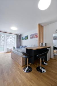 1 dormitorio con 1 cama y escritorio con 2 taburetes en JollyGarden Suite by Rentez, en Praga
