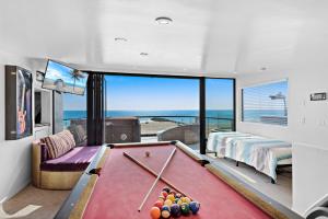 3 Story Oceanfront Home with Jacuzzi in Newport Beach on the Sand! في شاطئ نيوبورت: طاولة بلياردو في غرفة مطلة على المحيط