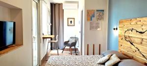 Un dormitorio con una cama, un televisor y una silla. en Room and suite Trinacria View, en Catania