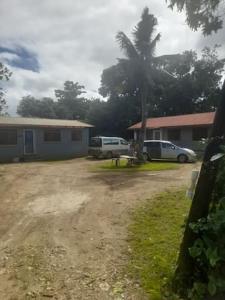 a house with two cars parked in a yard at Kapeta Cabin in Hofoa