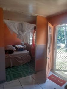 1 dormitorio con 1 cama y puerta abierta en Kapeta Cabin, en Hofoa