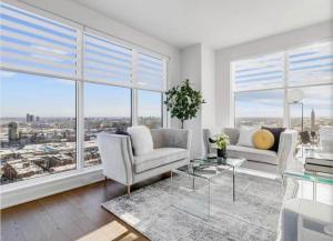 a living room with white furniture and large windows at Amazing city view - Penthouse - Pool & Spa - Downtown Montreal in Montreal